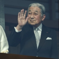 Emperor Emeritus Akihito waves to members of the public as Empress Emerita Michiko looks on during the New Year\'s appearance by the imperial family at the Imperial Palace in Tokyo on Jan. 2, 2020. | BLOOMBERG
