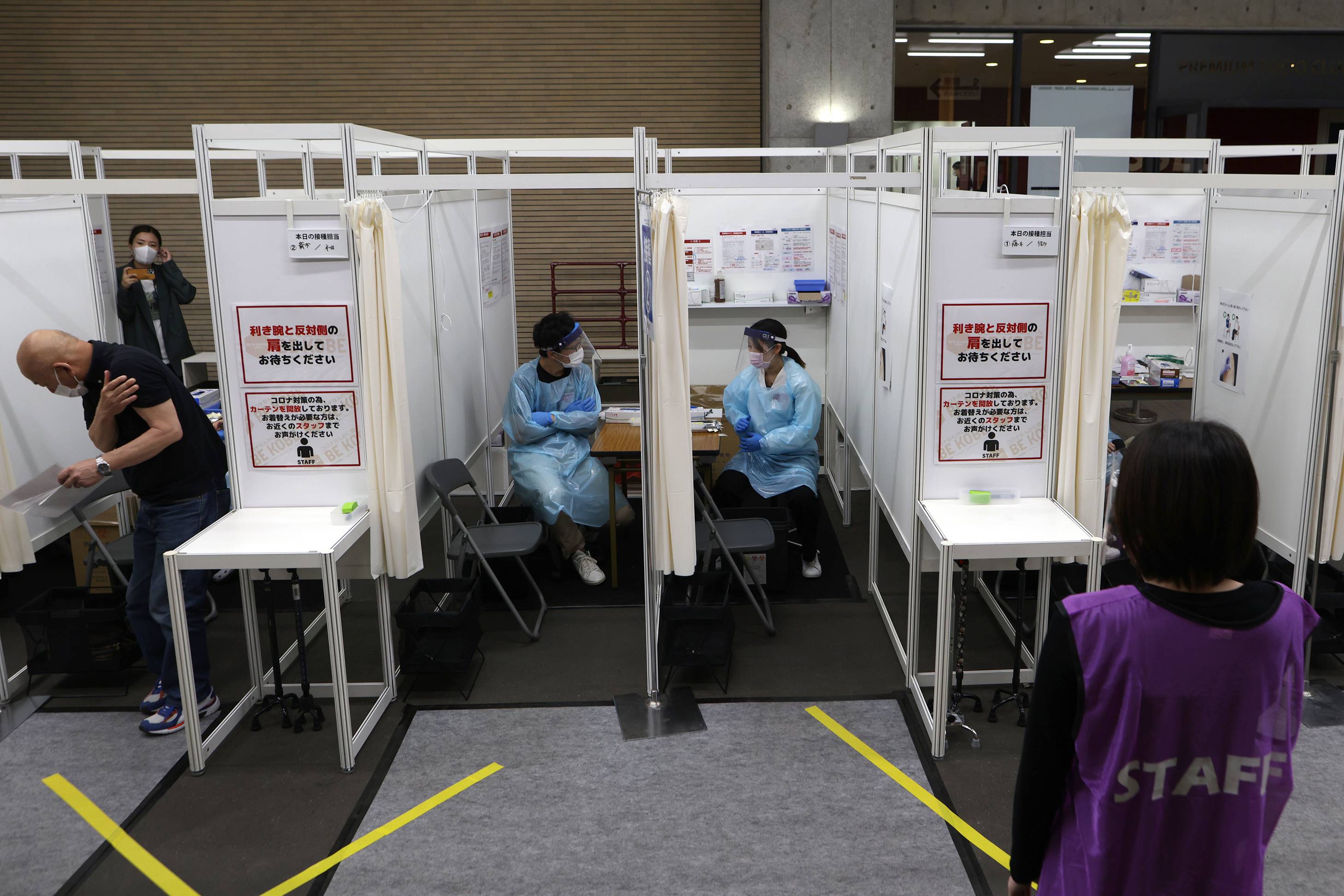 A man leaves after receiving a dose of the Pfizer-BioNTech COVID-19 vaccine at a mass-inoculation site at Noevir Stadium Kobe on Tuesday. After some false starts, Japan's much-delayed vaccine rollout is quietly picking up steam, now administering between 400,000 and 500,000 doses a day.  | BLOOMBERG
