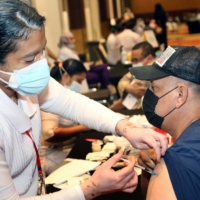 A health worker administers a dose of the Pfizer-BioNTech COVID-19 vaccine at a center in Kuwait City.  | AFP-JIJI