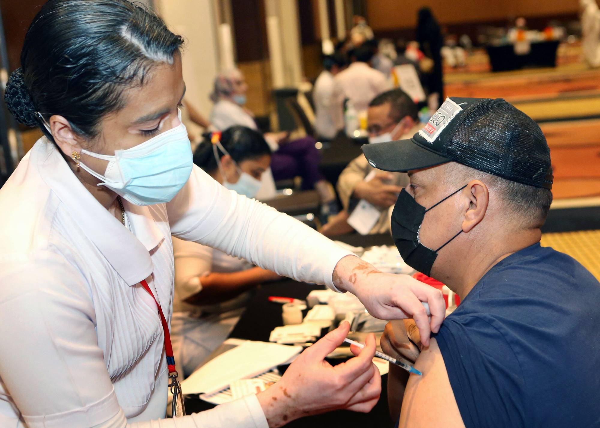 A health worker administers a dose of the Pfizer-BioNTech COVID-19 vaccine at a center in Kuwait City. | AFP-JIJI