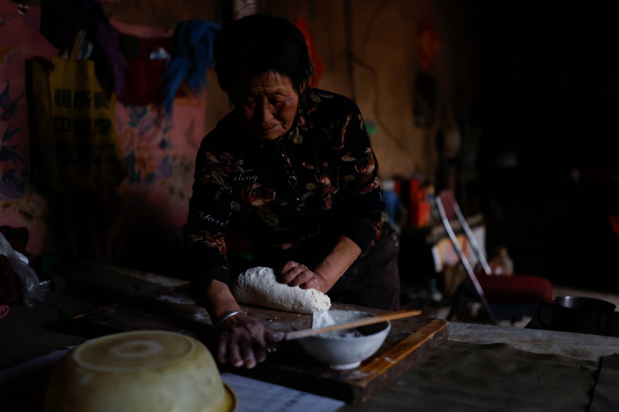 Ding Yinhua, 69, a shepherd, kneads dough for next day's noodles at her house in Minqin county, Wuwei. | Reuters 