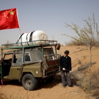Wang Tianchang waters a tree on the outskirts of Wuwei. | REUTERS 