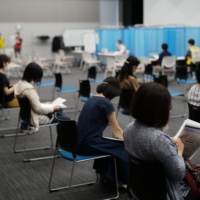 Around 200 nurses — most of whom volunteered to help at a vaccination site set to open on June 8 at the former location of Tsukiji Market — received their first dose Sunday at the Tokyo Nursing Association office in Shinjuku Ward. | RYUSEI TAKAHASHI
