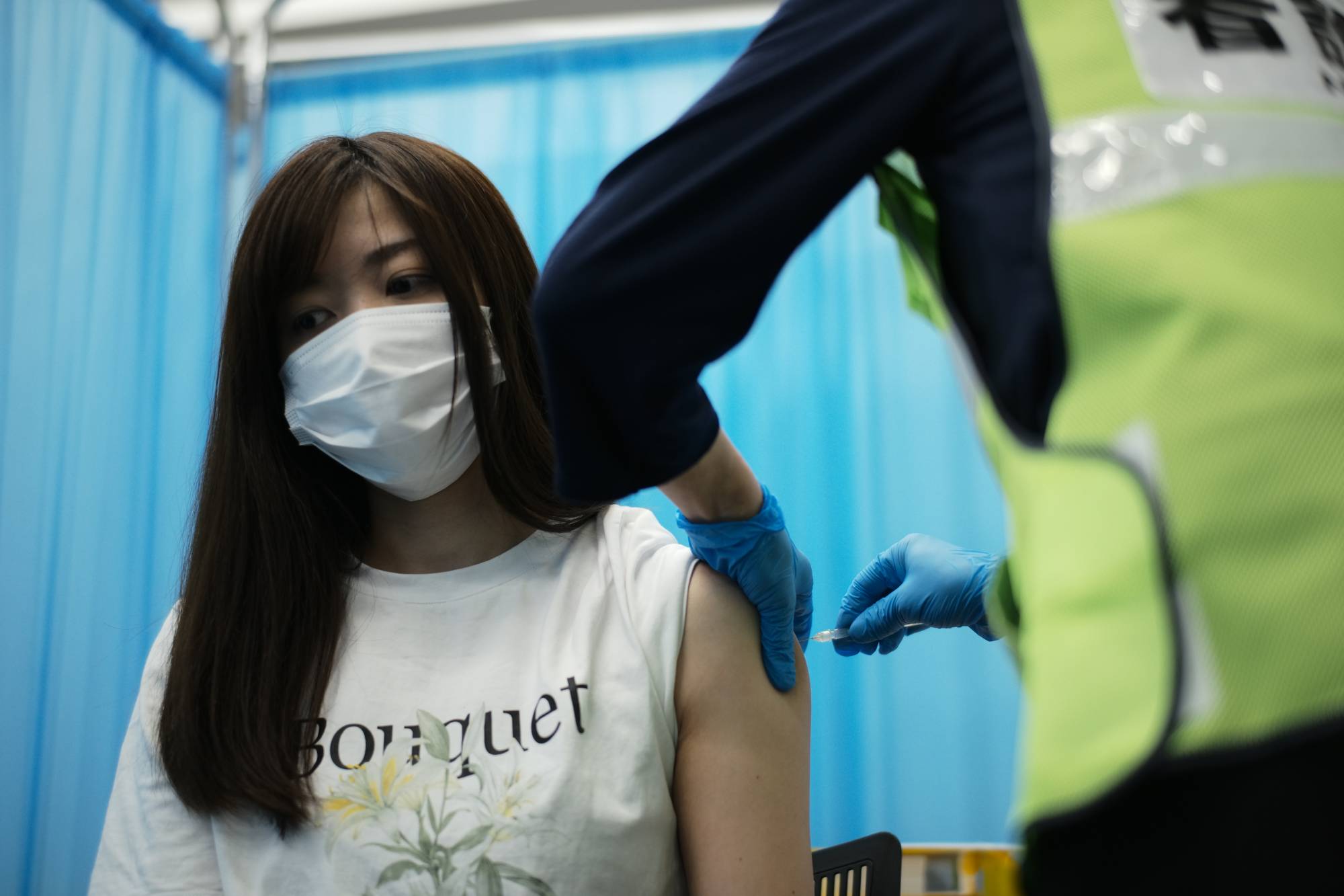A nurse receives a vaccine dose on Sunday in Tokyo's Shinjuku Ward.  | RYUSEI TAKAHASHI