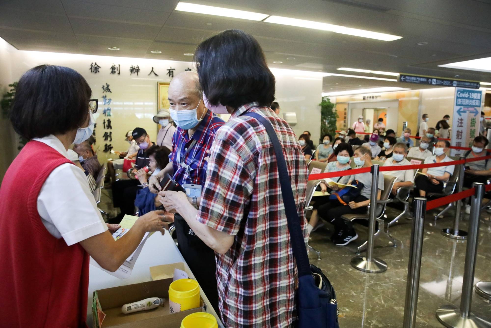 People ask about registering for COVID-19 vaccinations at the Far Eastern Memorial Hospital in New Taipei City, Taiwan, on May 13. | BLOOMBERG