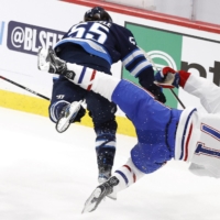 Jets center Mark Scheifele (left) hits Canadiens center Jake Evans (71) in the third period of their playoff game in Winnipeg, Manitoba on Tuesday. | USA TODAY / VIA REUTERS