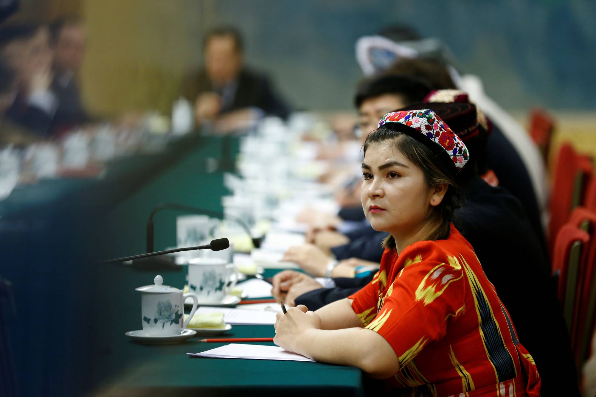 A delegate wearing traditional clothing attends a session of the Xinjiang Uyghur Autonomous Region on the sidelines of the National People's Congress at the Great Hall of the People in Beijing in 2018. | REUTERS 