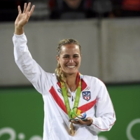 Monica Puig waves during the victory ceremony after winning the women\'s singles gold medal at the 2016 Rio Games.  | REUTERS
