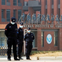 Security personnel keep watch outside the Wuhan Institute of Virology during a visit by a World Health Organization team in February.  | REUTERS 