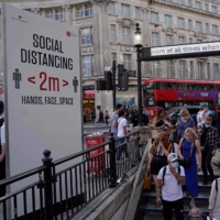 Commuters enter Oxford Circus station in central London on Monday. In England and Scotland, early evidence suggests the delta strain — which is now dominant there — carries a higher risk of hospitalization. | AFP-JIJI