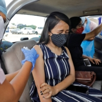 A woman is vaccinated in Ahmedabad, India, in May. The world’s largest vaccine-maker, the Serum Institute of India, was last year named a top supplier of shots to COVAX, the World Health Organization-backed initiative aimed at securing an equitable global rollout. | REUTERS