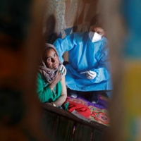 A woman receives a dose of a COVID-19 vaccine in Kashmir\'s Pulwama district on Monday. | REUTERS 