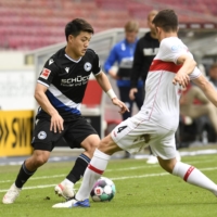 Arminia Bielefeld\'s Ritsu Doan (left) and VfB Stuttgart\'s Marc Oliver Kempf vie for the ball during a match in Stuttgart, Germany, on May 22. | POOL / VIA REUTERS