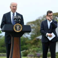 U.S. President Joe Biden delivers a speech on the COVID-19 pandemic as Pfizer CEO Albert Bourla stands alongside him in St. Ives, England, on Thursday. | AFP-JIJI