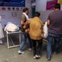 Relatives carry a man for treatment inside an emergency ward of a government-run hospital in Bijnor district, in Uttar Pradesh, India, on May 11. Overcrowded government hospitals with long lines and poor facilities have prompted people to spend out of pocket for better treatment in the private sector. | REUTERS