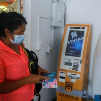 A woman prepares to make a transaction using bitcoins at a support office for use of the cryptocurrency in Chiltiupan, El Salvador, on June 8. | REUTERS 