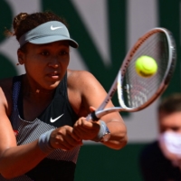 Naomi Osaka hits a return against Patricia Maria Tig during the first round of the French Open in Paris on May 30. | AFP-JIJI