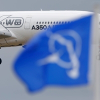 An Airbus A350 flies over a Boeing flag while landing after a flying display during the Paris Air Show at Le Bourget airport in 2015.  | REUTERS 