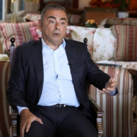 Fugitive former car executive Carlos Ghosn speaks as he sits next to his wife, Carole Ghosn, during an interview in Beirut on Monday. | REUTERS