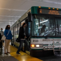 Commuters board a bus at the Salesforce Transit Center in San Francisco on June 9. | BLOOMBERG 