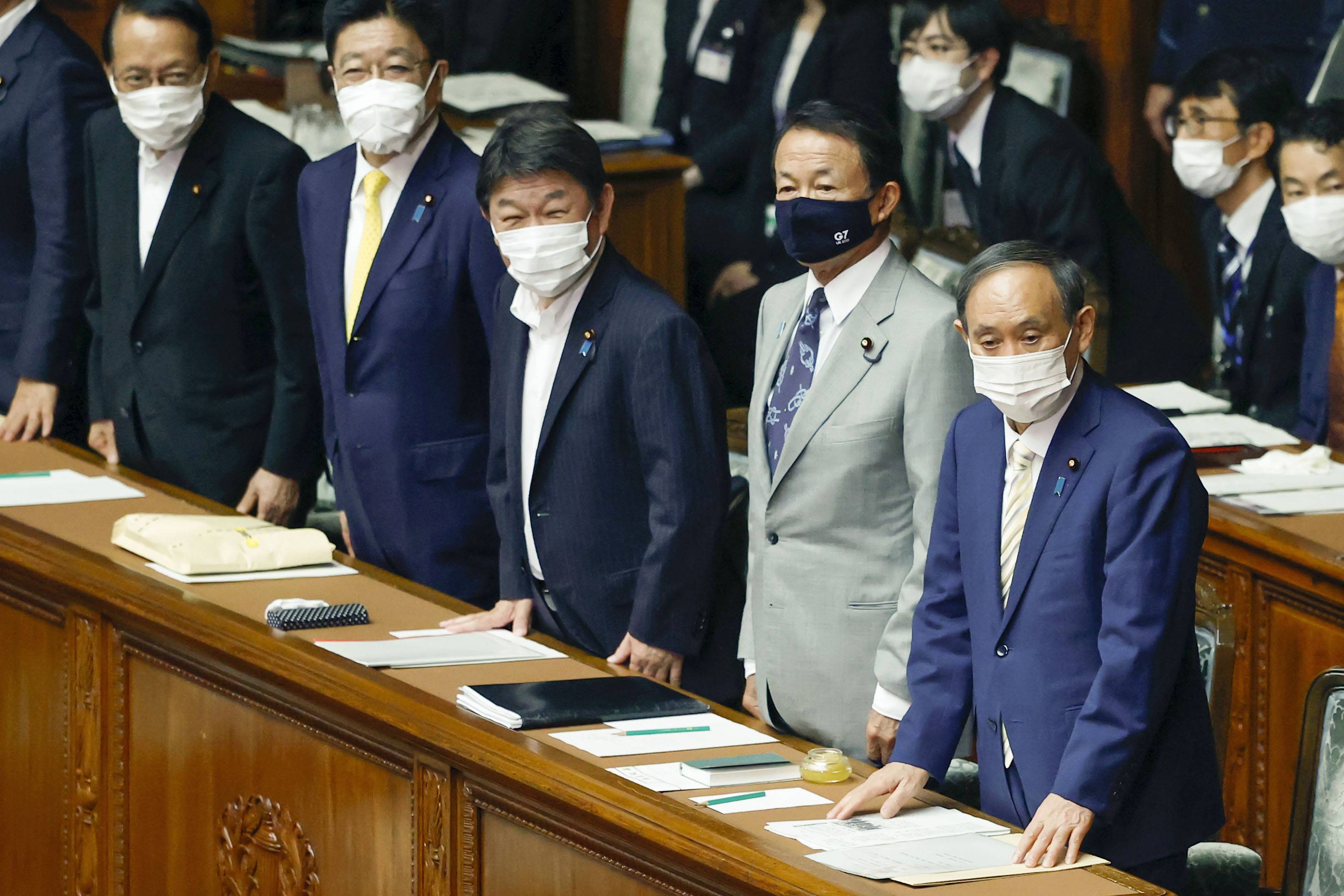 Prime Minister Yoshihide Suga (right) and his Cabinet ministers attend a Lower House plenary session on Tuesday. | KYODO