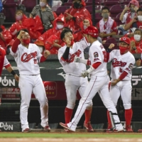 Carp players greet rookie Koki Ugusa (third from right) after his two-run home run against the Lions on Tuesday in Hiroshima. | KYODO