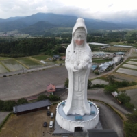 A drone picture shows a mask placed on a giant statue of Buddhist goddess Kannon at Houkokuji Aizu Betsuin temple in Aizuwakamatsu, Fukushima Prefecture, on Tuesday. | OISO ALL SUPPORT / VIA REUTERS