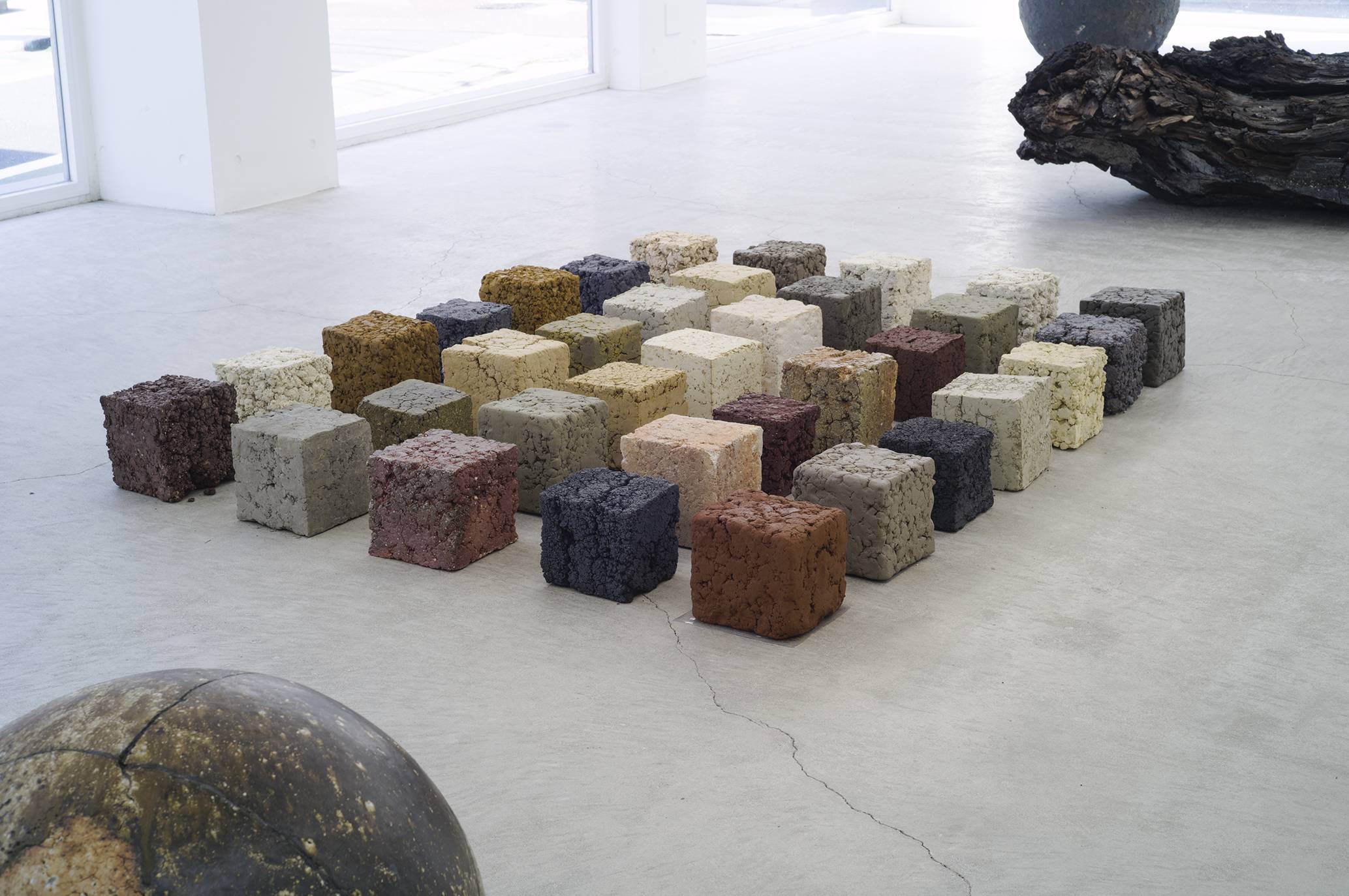 A display of large clay cubes at architect Bijoy Jain’s Mino Soil “Material” exhibition in Tokyo showcases the variety of colors that can be produced from clay soil mined in Gifu Prefecture.  | YURIKA KONO