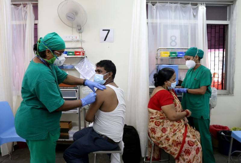 A man and a woman receive their first dose of a COVID-19 vaccine in Mumbai on May 3. | REUTERS