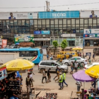 Vehicles and pedestrians walk past a computer market in Lagos on March 29. | BLOOMBERG