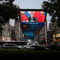 A large screen outside a shopping mall in Beijing shows a news report about Chinese President Xi Jinping on May 19. | AFP-JIJI