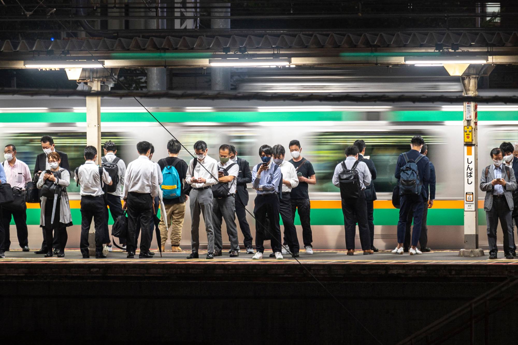 People wait for trains at a station in Tokyo on Wednesday. The pandemic forced businesses to adopt telework to avoid spreading the virus, and a metropolitan government survey conducted last July showed that Tokyo's telework rate had jumped to 57.8%. | AFP-JIJI