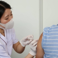 A man gets an injection of a COVID-19 vaccine at the Tokyo Metropolitan Government office in the capital Friday. | POOL / VIA REUTERS