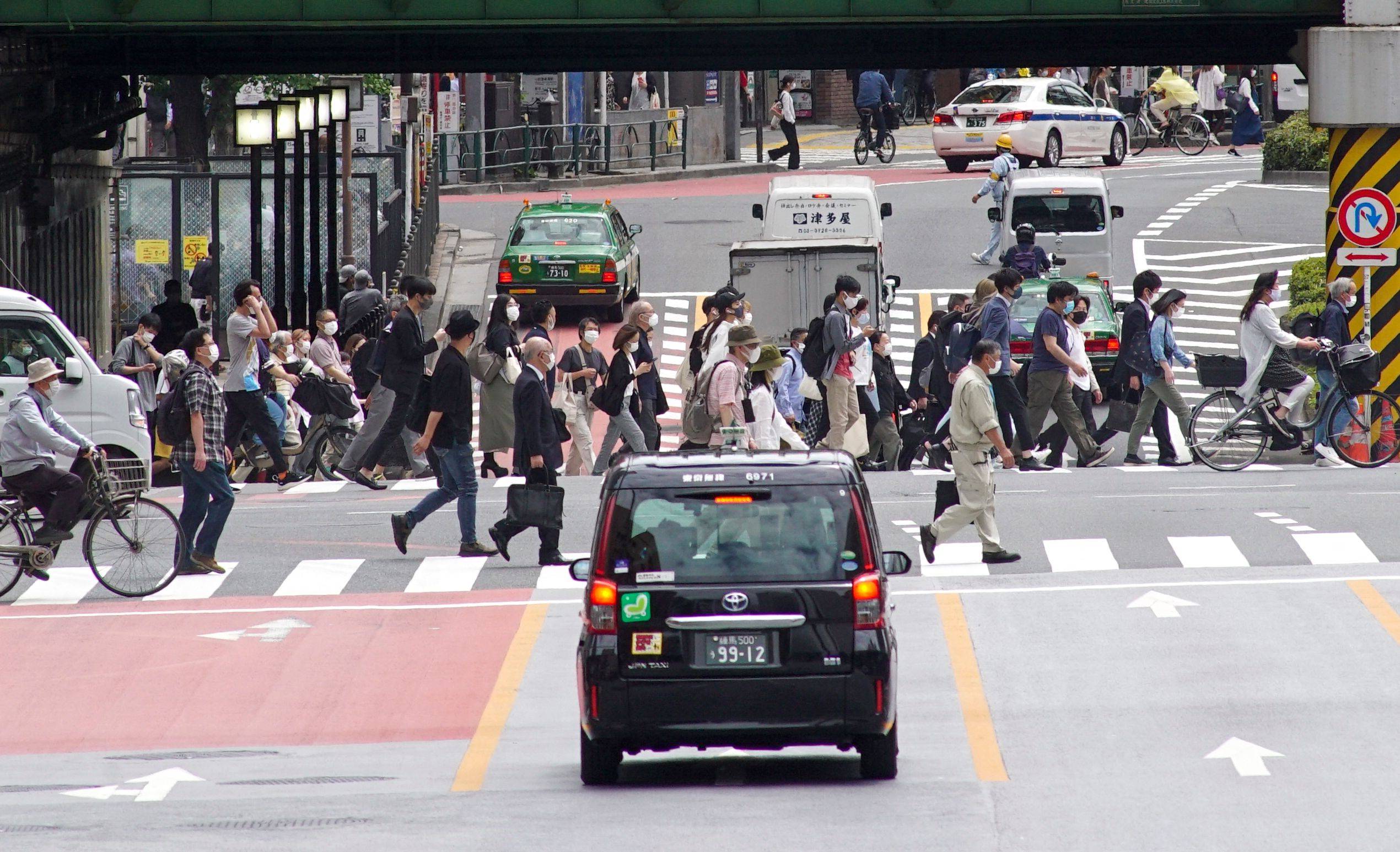 Commuters walk near JR Shinjuku Station in Tokyo. The government plans to encourage firms to let their employees choose to work four days a week instead of five, but it's unclear if the initiative will be widely accepted, with both the labor and management side voicing concerns about potential unwanted outcomes. | AFP-JIJI