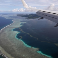 A plane carrying then-U.S. Secretary of State Mike Pompeo makes its landing approach to Pohnpei International Airport in Kolonia, Federated States of Micronesia, in August 2019. A World Bank-led project has declined to award a contract to lay sensitive undersea communications cables after Pacific island governments heeded U.S. warnings that participation of a Chinese company posed a security threat. | REUTERS