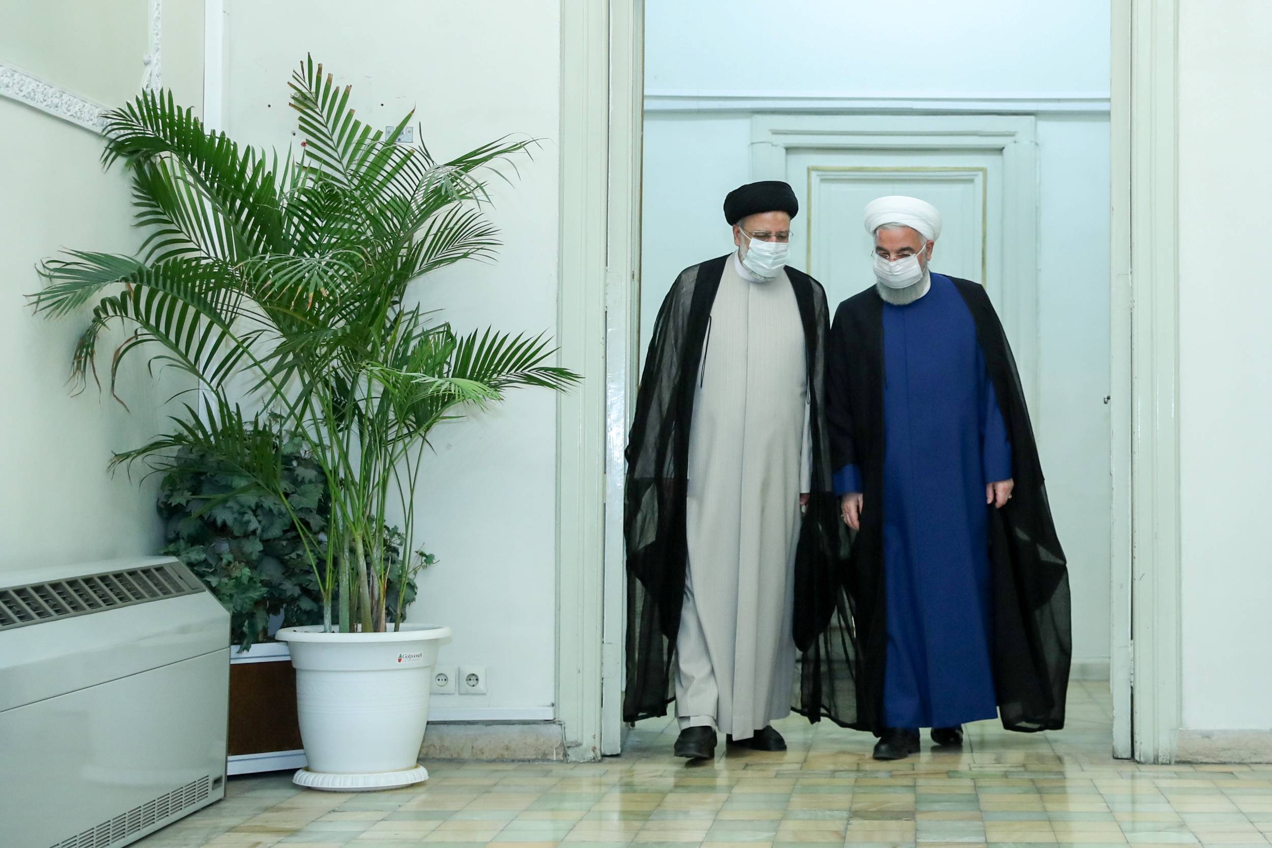 Iran's outgoing president, Hassan Rouhani, meets with President-elect Ebrahim Raisi in Tehran on Saturday. | Iranian presidential website / via REUTERS