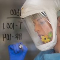 A nurse writes information on the window of a patient\'s room at a hospital in Salinas, California, in January. | BLOOMBERG 