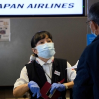 A Japan Airlines agent helps a passenger at Los Angeles International Airport in November. | AFP-JIJI