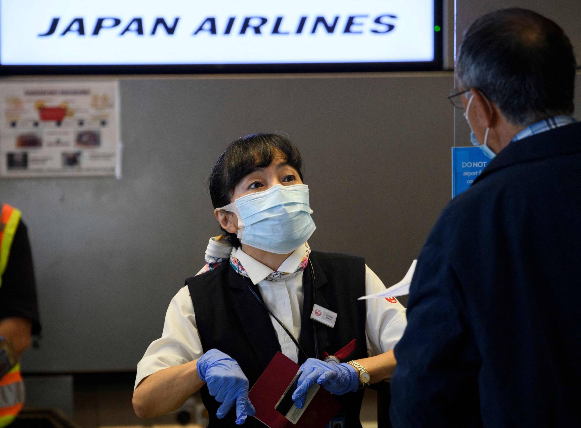 A Japan Airlines agent helps a passenger at Los Angeles International Airport in November. | AFP-JIJI