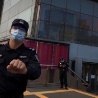 A photographer is prevented from taking pictures outside an H&M outlet in Beijing in April amid a Chinese boycott against the company for expressing concern over the alleged use of forced labor of Muslims in Xinjiang province. | REUTERS

