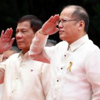 Incoming President Rodrigo Duterte and outgoing President Benigno Aquino salute the honor guards before Aquino leaves the Malacanang Palace in Manila in June 2016. | REUTERS 