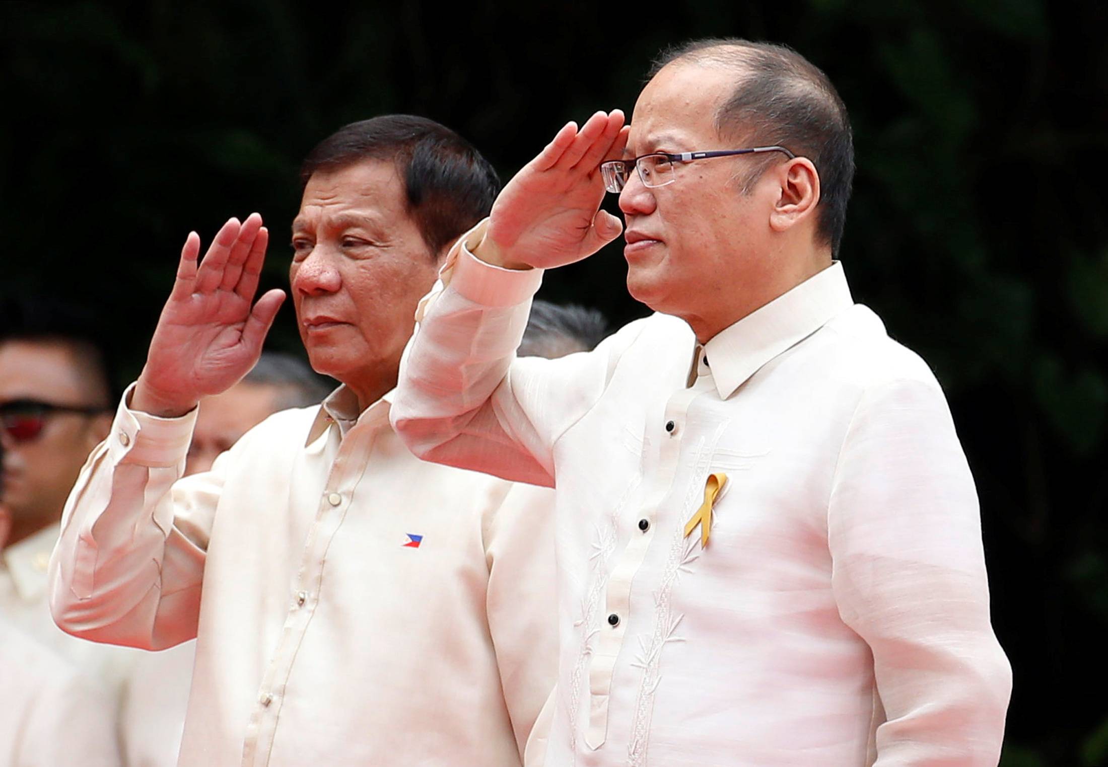 Incoming President Rodrigo Duterte and outgoing President Benigno Aquino salute the honor guards before Aquino leaves the Malacanang Palace in Manila in June 2016. | Reuters 