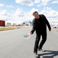 Tesla CEO Elon Musk holds a helmet as he visits the construction site of Tesla\'s gigafactory in Gruenheide, near Berlin, in May.  | REUTERS 