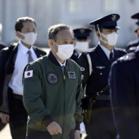 Prime Minister Yoshihide Suga reviews Air Self-Defense Force personnel at Iruma Air Base in Sayama, Saitama Prefecture, last November. | POOL / VIA REUTERS