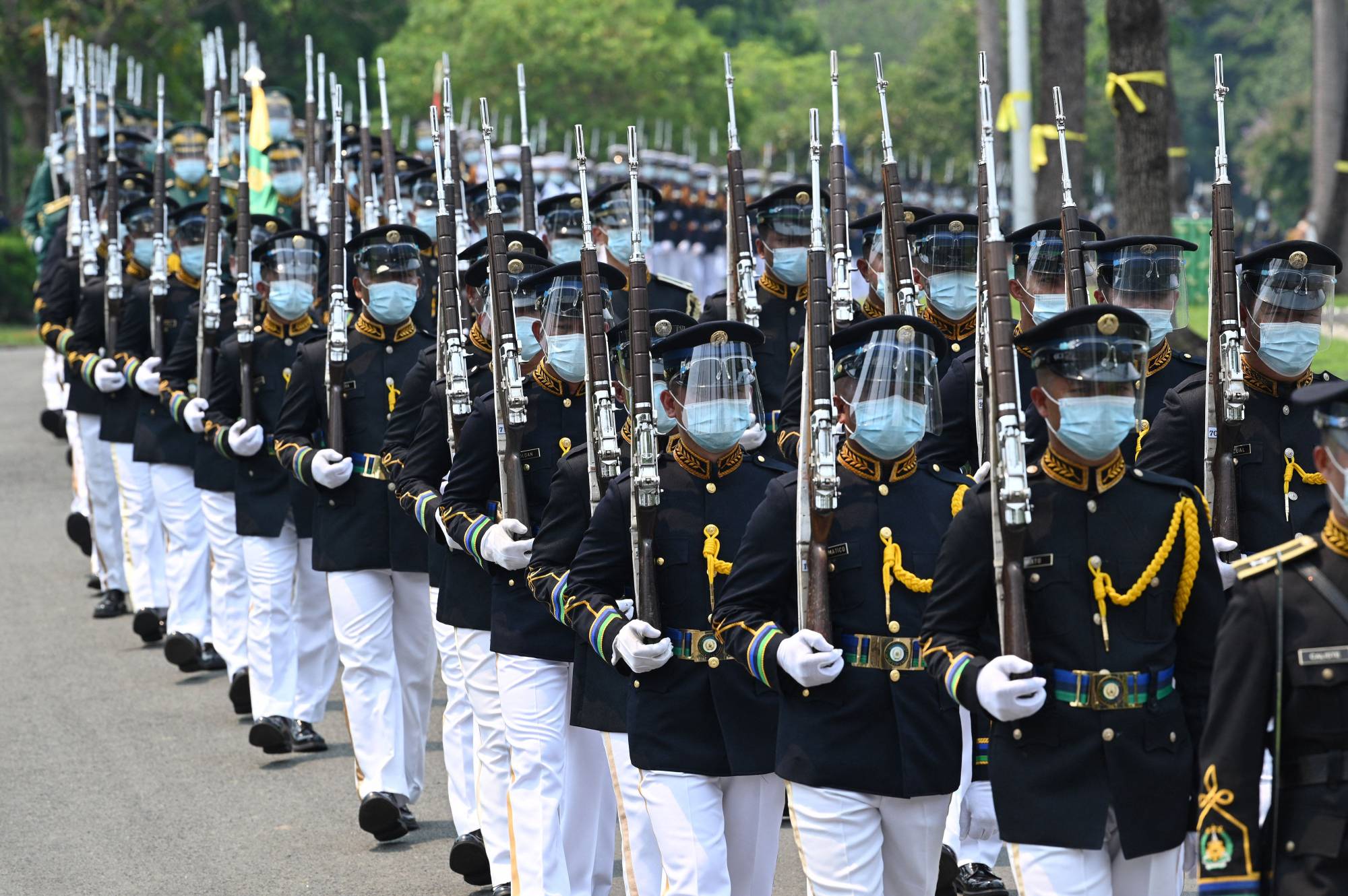 Philippine military honor guards march as they escort the carriage carrying the urn of the late President Benigno Aquino at a memorial in Manila on Saturday. | AFP-JIJI