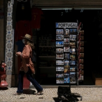 A woman wearing a protective mask walks in downtown Lisbon on Thursday. | REUTERS