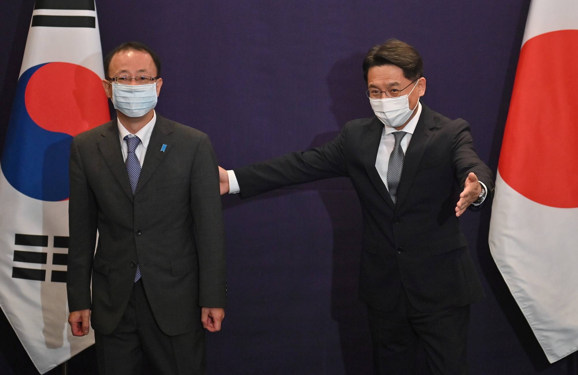 Noh Kyu-duk, South Korea's special representative for Korean Peninsula peace and security affairs, ushers Takehiro Funakoshi, director-general of the Foreign Ministry's Asian and Oceanian Affairs Bureau, during their bilateral meeting in Seoul on June 21. | Pool / via REUTERS