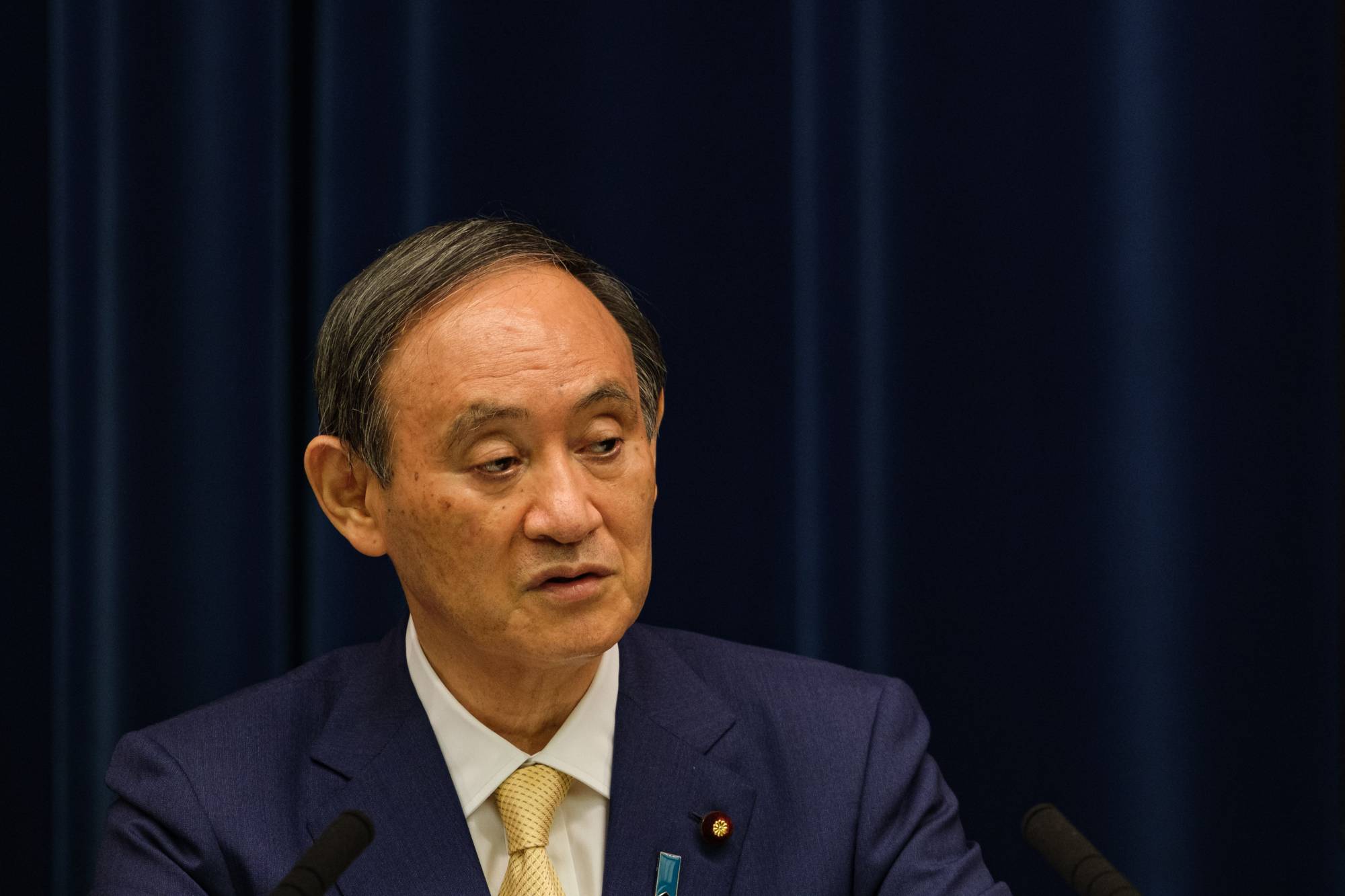 Prime Minister Yoshihide Suga speaks during a news conference in Tokyo on July 8. | Bloomberg