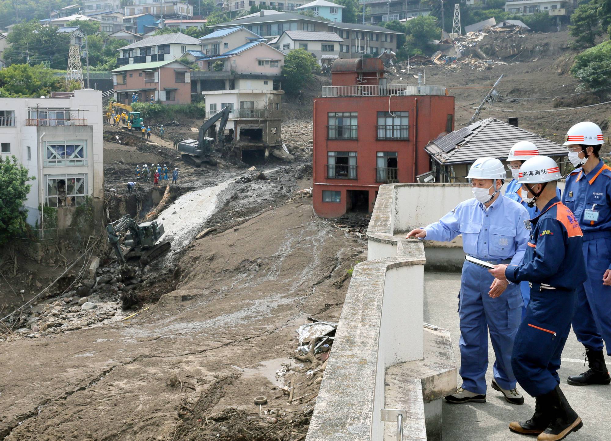 Japanese Prime Minister Yoshihide Suga surveys the mudslide-hit city of Atami, Shizuoka Prefecture, on July 12.  | KYODO