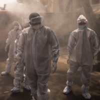 Front-line workers are sprayed with disinfectant at a COVID-19 care center in Uttar Pradesh, India, in May. | BLOMBERG 